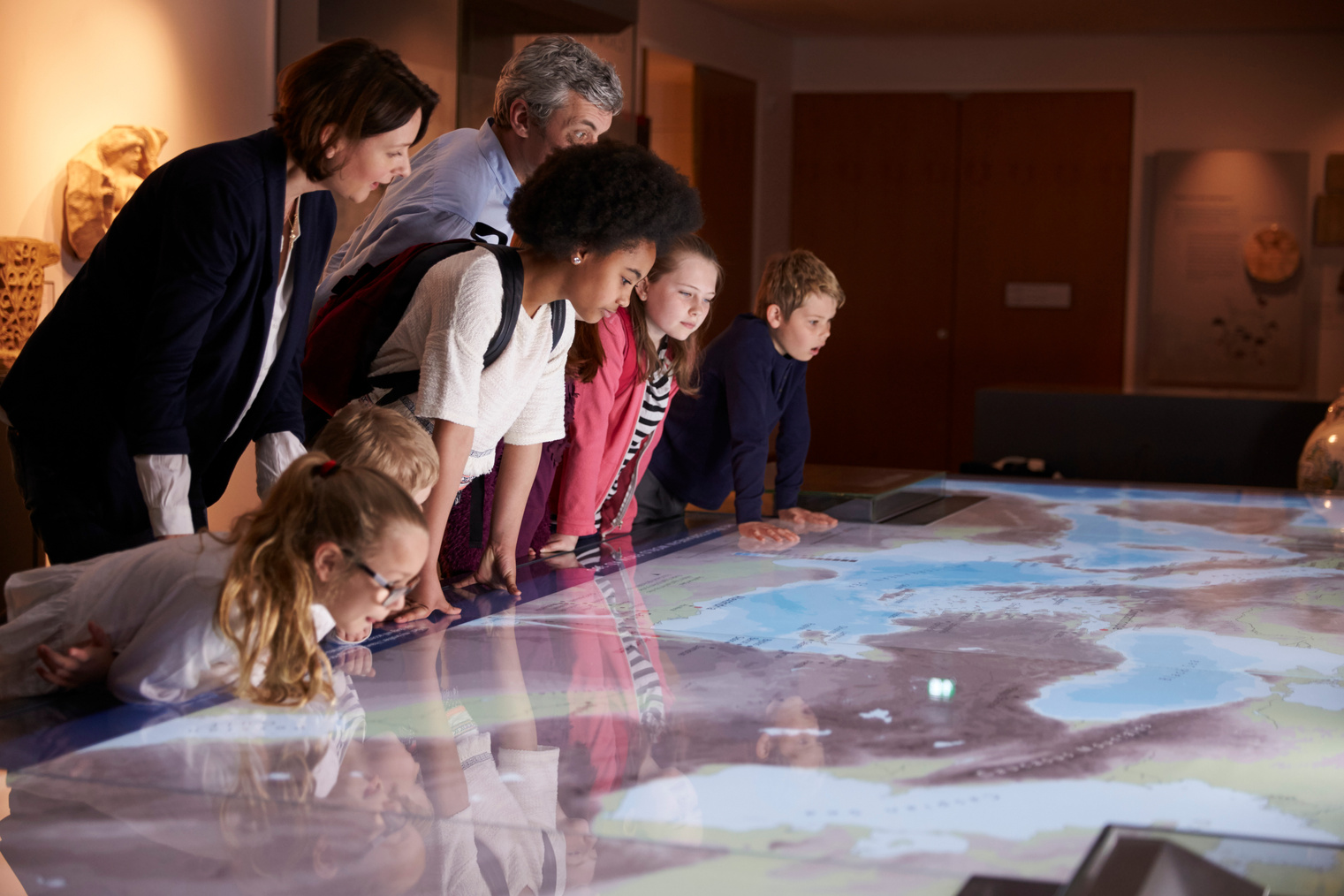 Pupils on School Field Trip to Museum Looking at Map